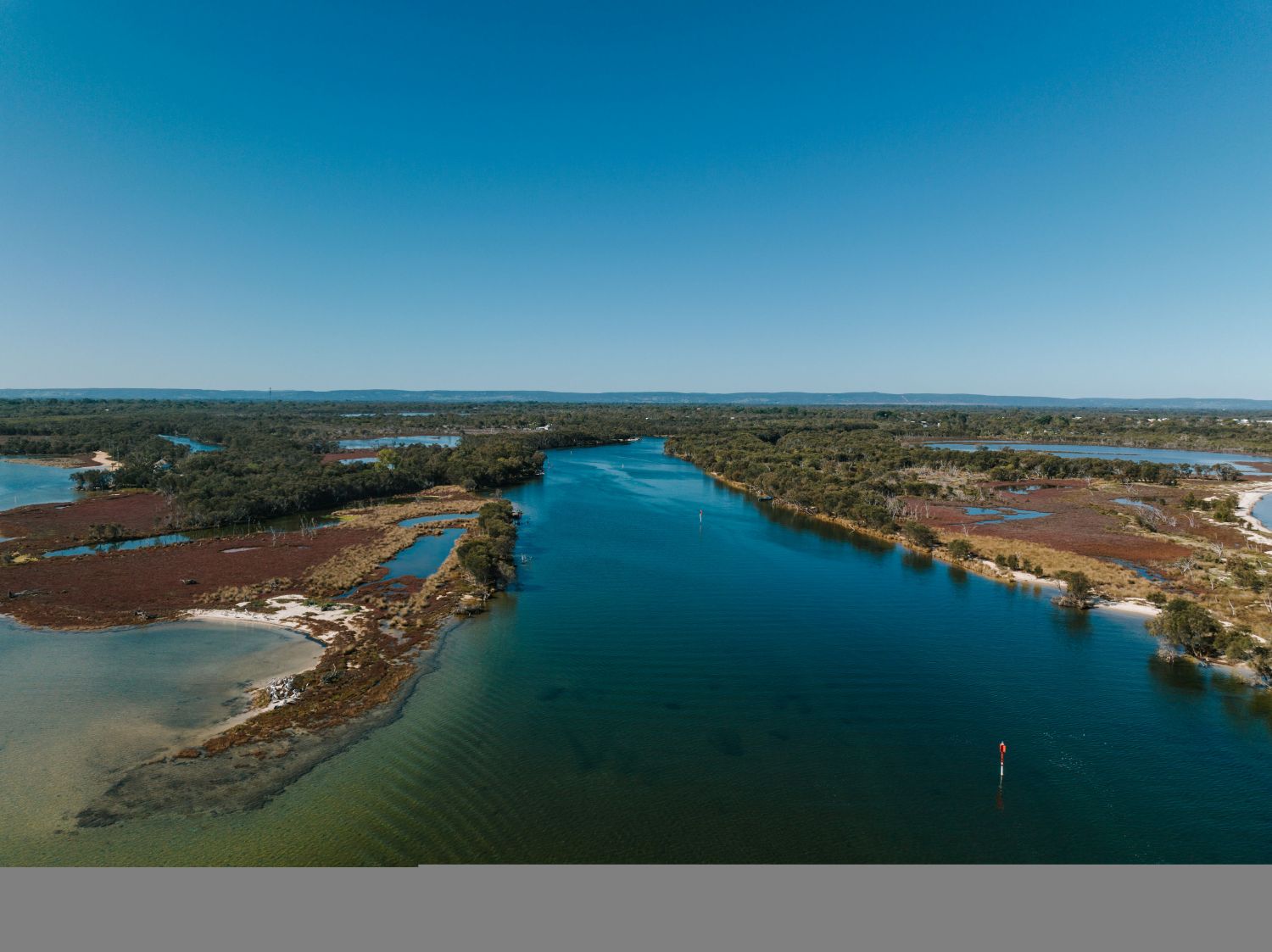 Aerial view of the wetlands and bushland next to the estuary in Mandurah on a sunny day.